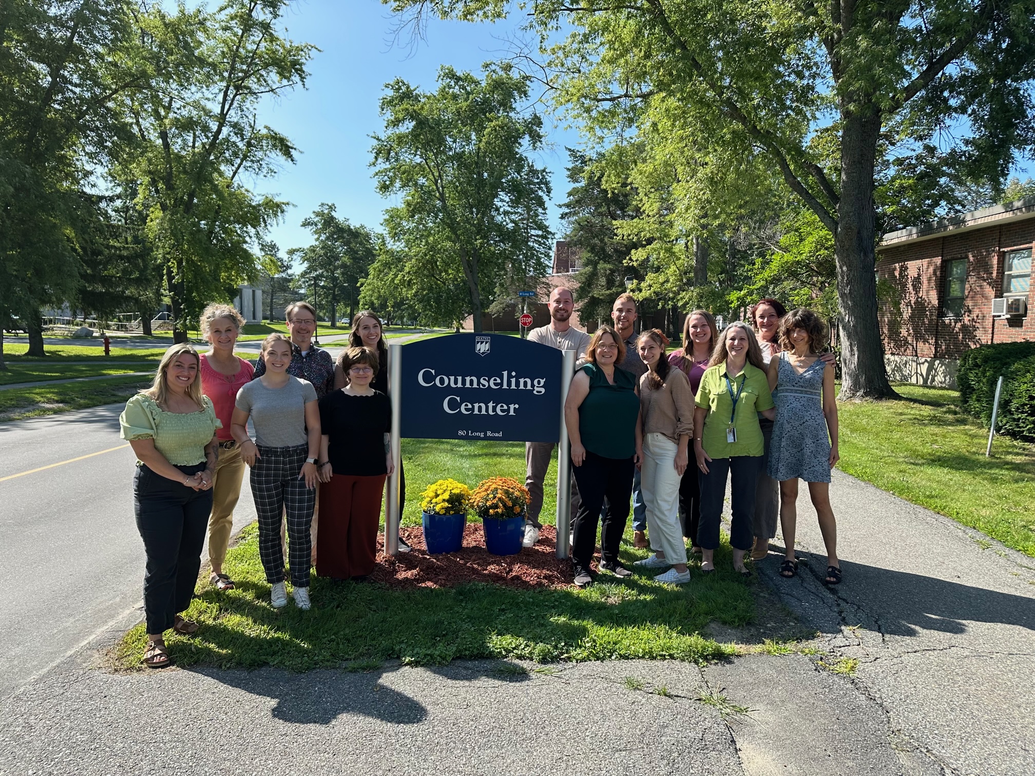 Counseling Center staff in front of Counseling Center sign