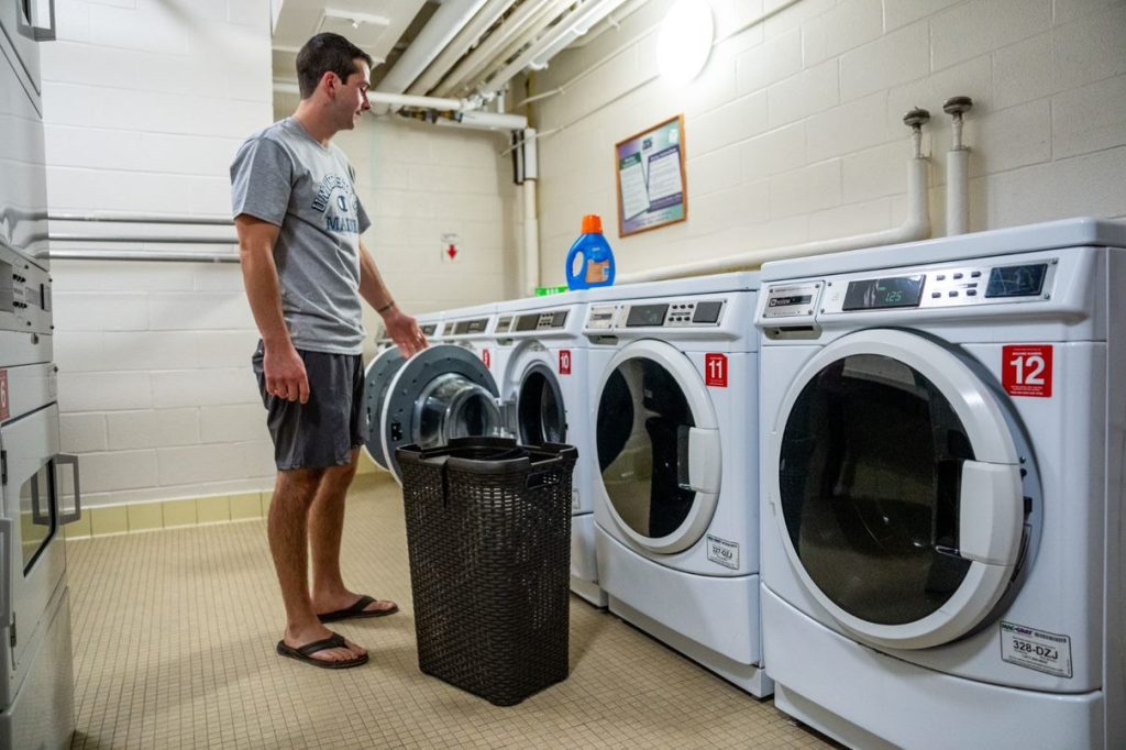 student doing laundry in residence hall facility